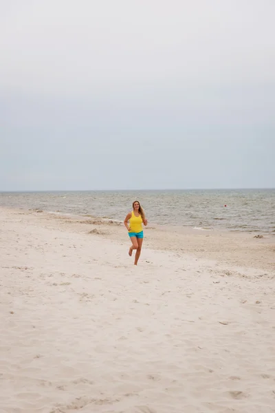 Young woman running on the beach — Stock Photo, Image