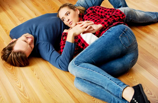 Jovem casal feliz deitado no chão — Fotografia de Stock