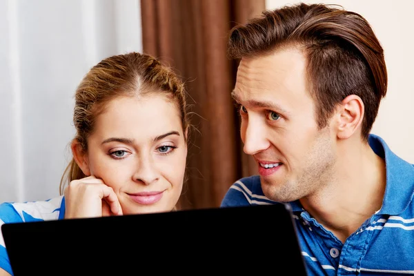 Cuplu tânăr caută ceva pe laptop — Fotografie, imagine de stoc