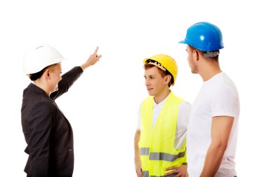 Kadın mühendis iki inşaatçıyla konuşuyor.