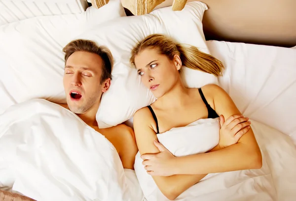 Пара в постели, мужчина храпит женщина не может спать — стоковое фото