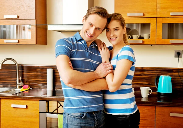 Adorável jovem casal de pé na cozinha — Fotografia de Stock