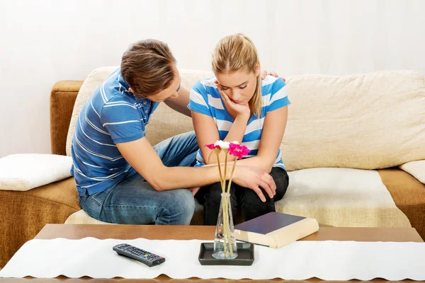 Man troostend zijn boos partner in woonkamer — Stockfoto