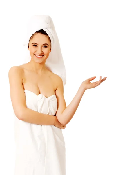 Spa woman wrapped in towel showing something on palm — Stock Photo, Image