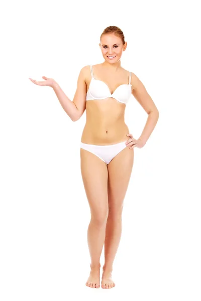 Happy woman in white lingerie presenting something on open palm — Stock Photo, Image