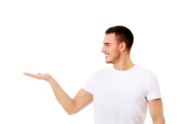 Young man showing something on palm — Stock Photo, Image