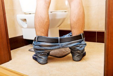 Man peeing in toilet at home clipart