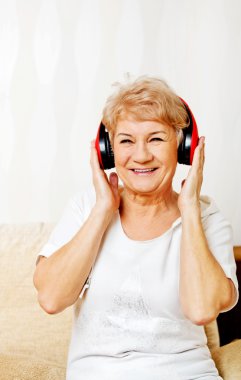 Kırmızı kulaklık takan mutlu son sınıf kadını.