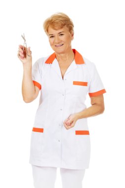 Yaşlı kadın doktor veya hemşire makas tutan gülümse