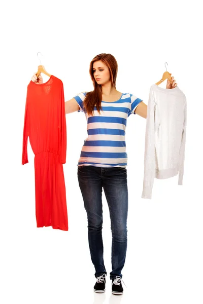 Mulher adolescente com duas camisas pensando o que vestir — Fotografia de Stock