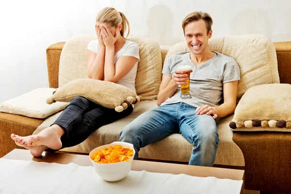 Žena sedí znuděný zatímco muž sleduje sport — Stock fotografie