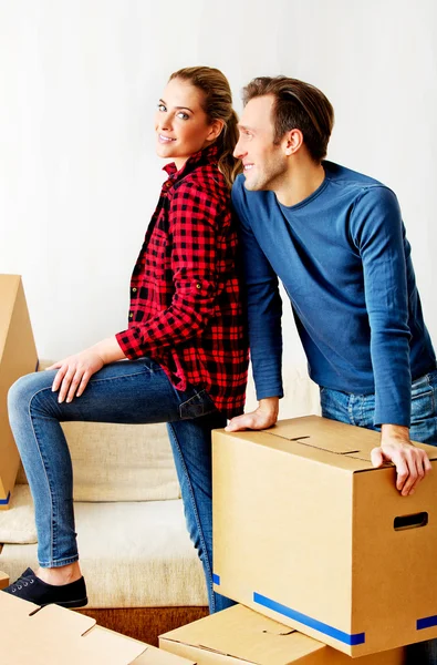 Happy couple carrying cardboard boxes in new home — Stock Photo, Image