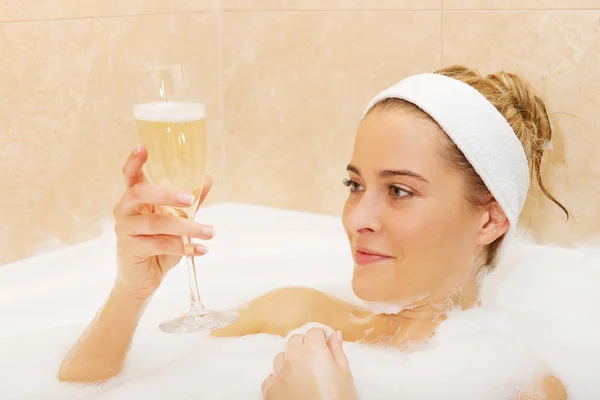 Vrouw ontspannen in bad met een glas champagne — Stockfoto