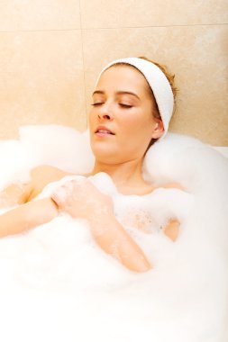 Genç bayan banyoda dinleniyor.