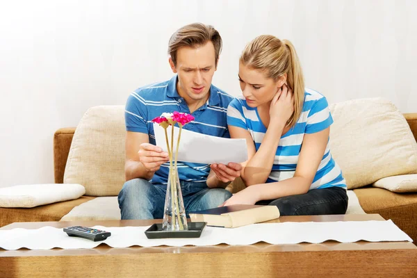 Casal jovem examinando planos de apartamento — Fotografia de Stock