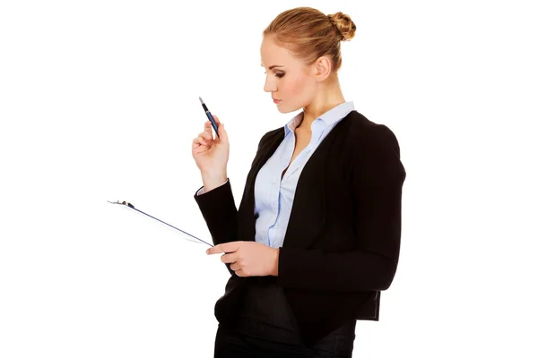 Thoughtful focused business woman holding clipboard — Stock Photo, Image