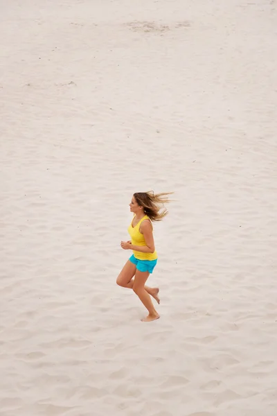 Mujer joven corriendo en la playa — Foto de Stock