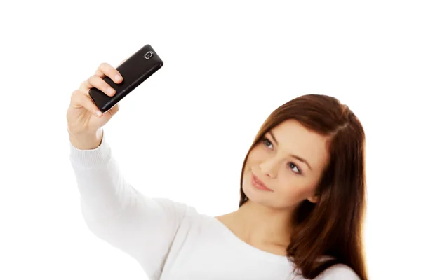 Happy young woman makes selfies with smart phone Royalty Free Stock Images