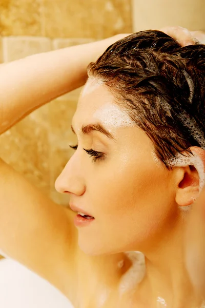 Νεαρή χαλαρωτική γυναίκα πλένει τα μαλλιά στο μπάνιο — Φωτογραφία Αρχείου