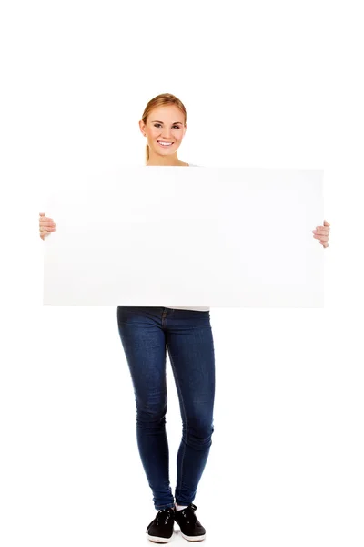 Glückliche junge Frau mit leerer Plakatwand — Stockfoto