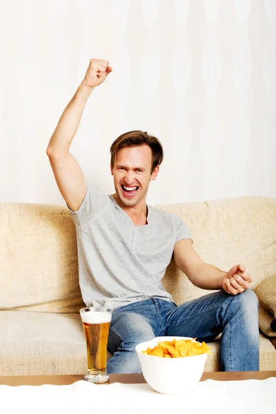 Jovem feliz assistindo esportes na tv — Fotografia de Stock