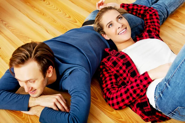 Young happy couple lying on the floor — Stock Photo, Image