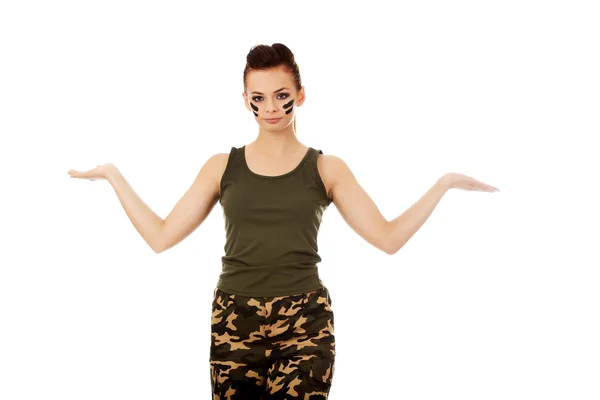 Молодая женщина-солдат представляет что-то на открытой ладони — стоковое фото