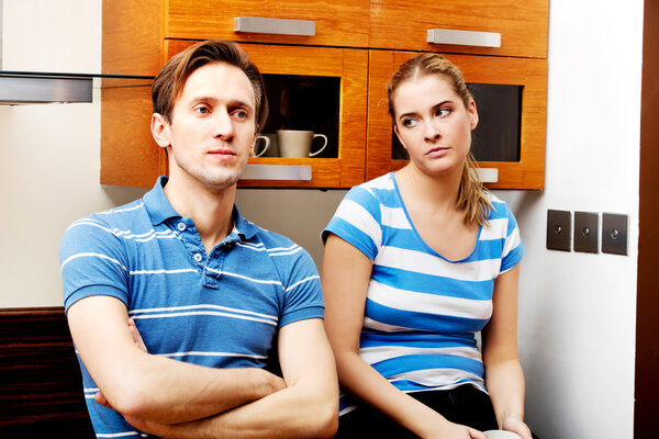 Молодая несчастная пара после ссоры на кухне

