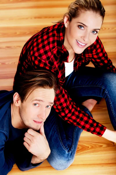 Young happy couple on the floor looking up — Stock Photo, Image