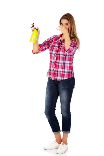 Junge Frau hält Sprühflasche in der Hand — Stockfoto