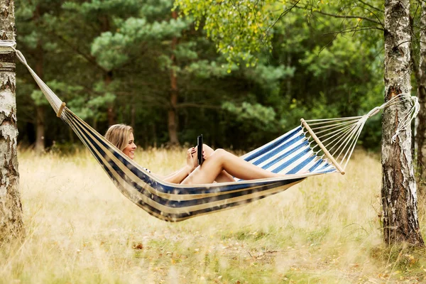 Young woman with tablet on the hammock — Stock Photo, Image