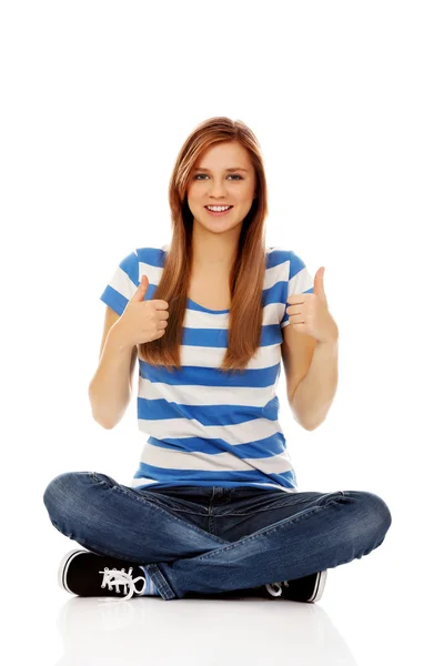 Happy teenage woman sitting with cross legged — Stock Photo, Image