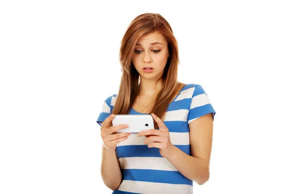 Teenage chockad kvinna läser ett meddelande på mobiltelefon — Stockfoto