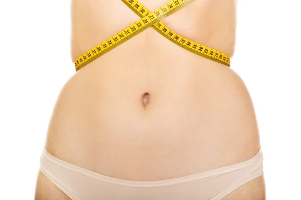 Fit junge Frau gebunden Maßband auf dem Bauch — Stockfoto