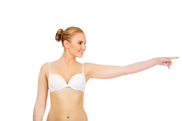Młoda kobieta w biały biustonosz wskazując na miejsce lub coś — Zdjęcie stockowe