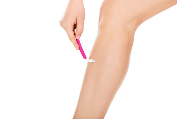 Mujer joven afeitarse las piernas afeitadora rosa — Foto de Stock