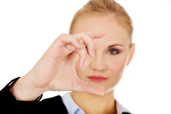 Joven empresaria mostrando espacio de copia o algo entre los dedos — Foto de Stock