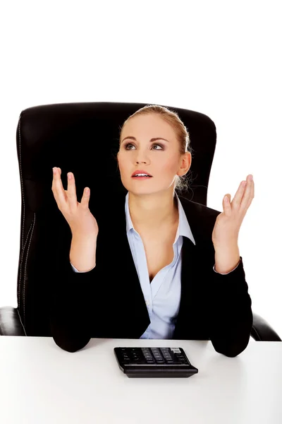 Nervous business woman count on the calculator beahind the desk — Stock Photo, Image