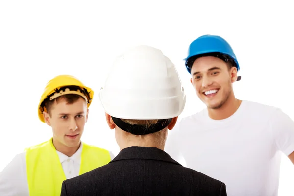 Vrouwelijke ingenieur in gesprek met twee bouwers — Stockfoto