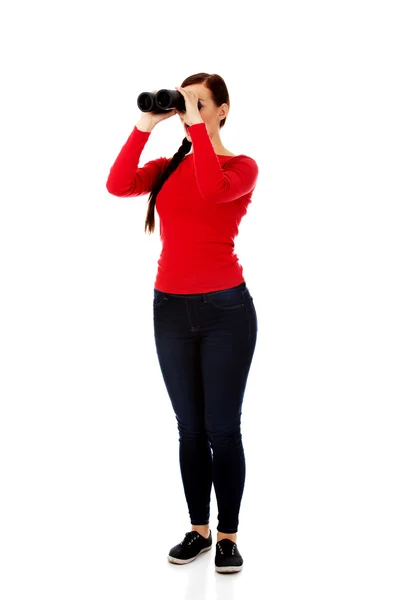 Young woman looking through a binocular — Stock Photo, Image