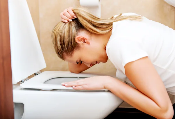 Young woman voimiting in the bathroom — Stock Photo, Image