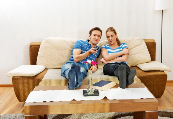 Ungt par sitter på soffan och tittar på Tv — Stockfoto