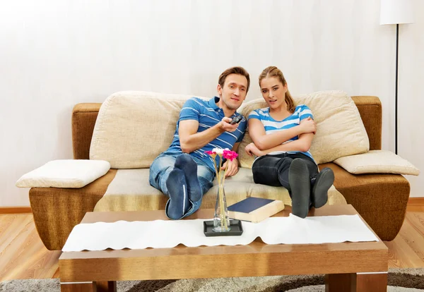 Pareja joven sentada en el sofá y viendo la televisión — Foto de Stock