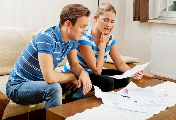 Besorgtes Ehepaar rechnet Rechnungen zu Hause ab — Stockfoto