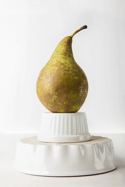 Ripe pear on the porcelain form — Stock Photo, Image