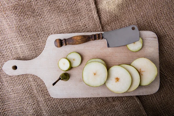 Sliced pear and chopper on the wooden cutting board — Stock Photo, Image