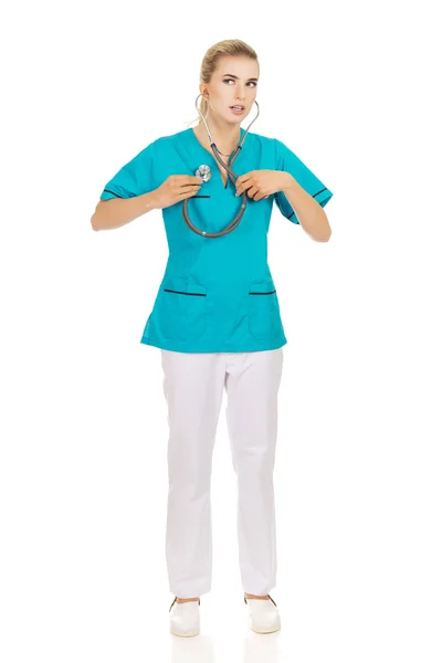 Młody nursre lub kobiece kobieta lekarz słuchać jej własne serce — Zdjęcie stockowe