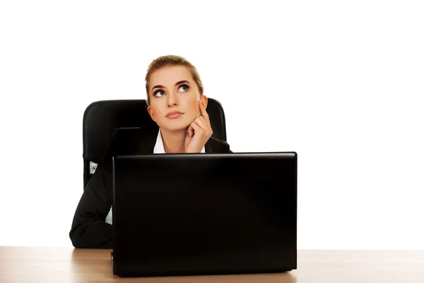 Dizüstü bilgisayar kullanan genç iş kadını masanın arkasında — Stok fotoğraf