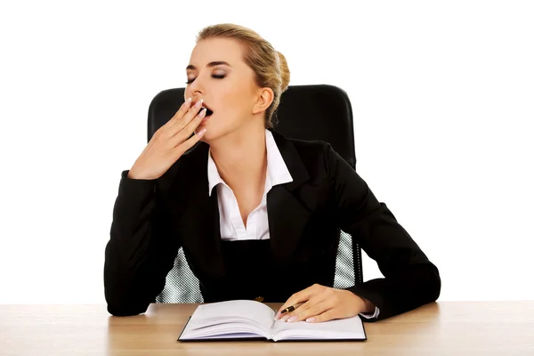 Empresaria bostezando escribiendo nota junto a un escritorio —  Fotos de Stock
