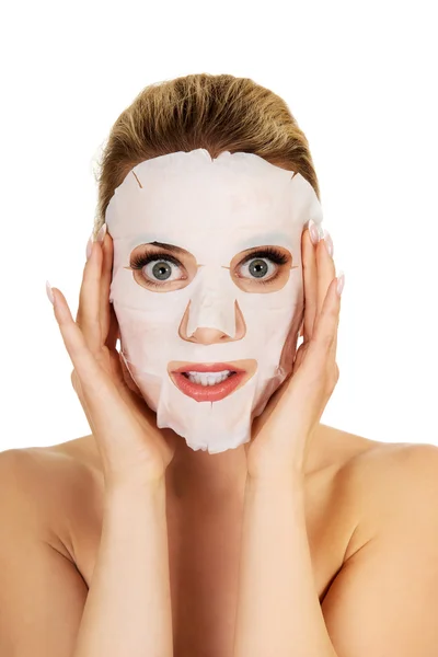 Mujer joven sorprendida con máscara facial — Foto de Stock